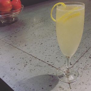 An image of the The French 75 cocktail submitted by n0tquitethere that contains London Dry Gin, Lemon, Simple Syrup, Champagne, Lemon and Cocktail Cherry