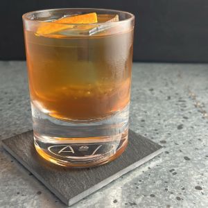 An image of the Heavy Artillery cocktail submitted by n0tquitethere that contains Rye Whiskey, Smith & Cross, Green Chartreuse, Sweet Vermouth, Cinnamon Syrup, Demerara Syrup, Whiskey Barrel Aged Bitters and Orange