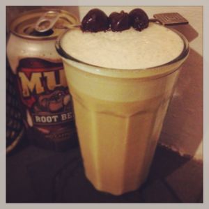 An image of the Hires Fizz cocktail submitted by n0tquitethere that contains Cynar, Cherry Brandy, Lemon, Cream, Egg, Angostura Bitters, Root Beer and Cocktail Cherry