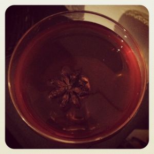 An image of the Reveillon Cocktail cocktail submitted by n0tquitethere that contains Apple Brandy, Pear Brandy, Allspice Dram, Dubonnet Rouge, Angostura Bitters and Star Anise